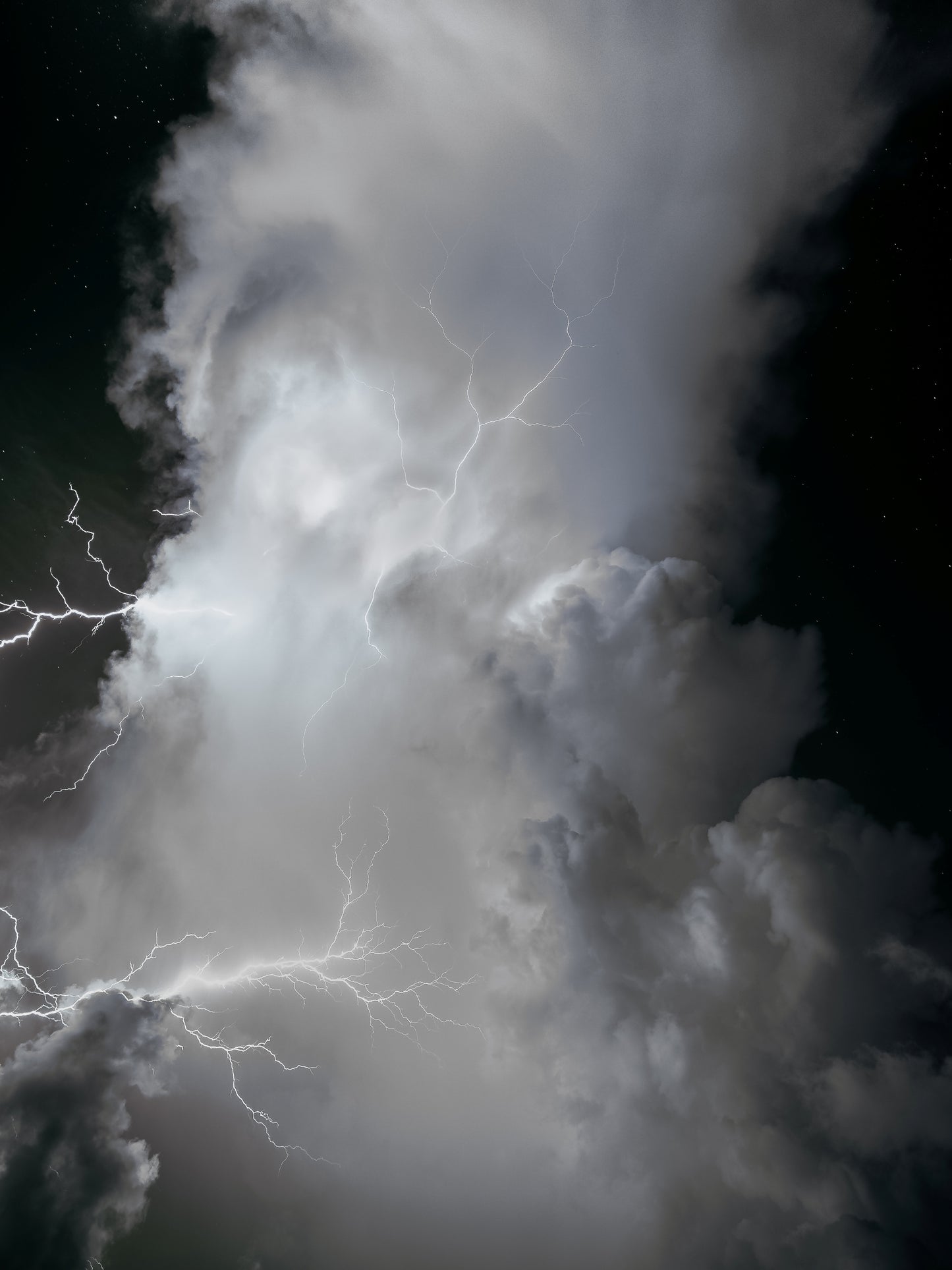 A black-and-white infrared storm cloud crackling with spider lightning against a starry night sky — fine art storm photography by Susan Gunn.