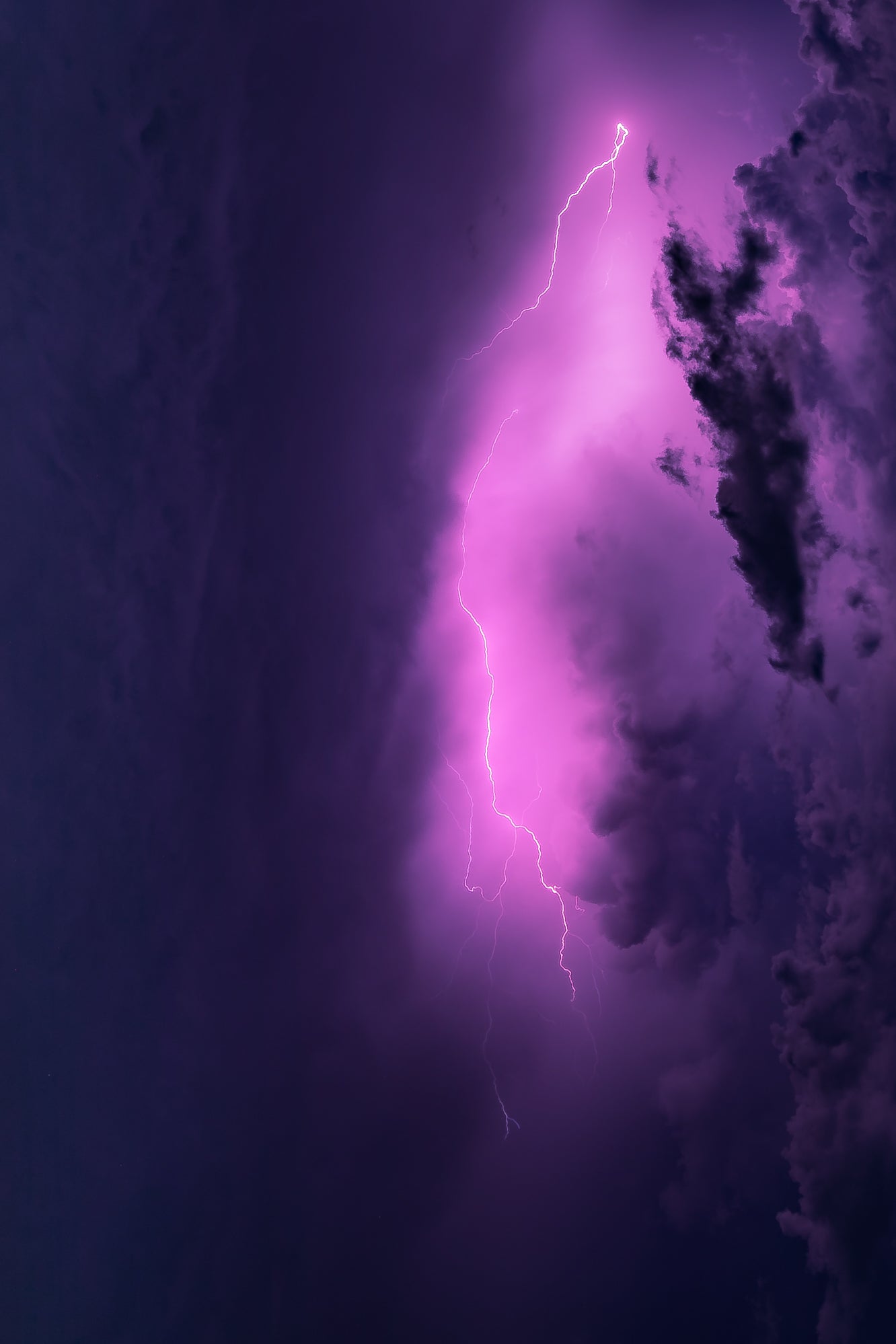 A single jagged bolt of lightning splitting a glowing violet storm cloud against a dark night sky — abstract fine art storm photography by Susan Gunn.