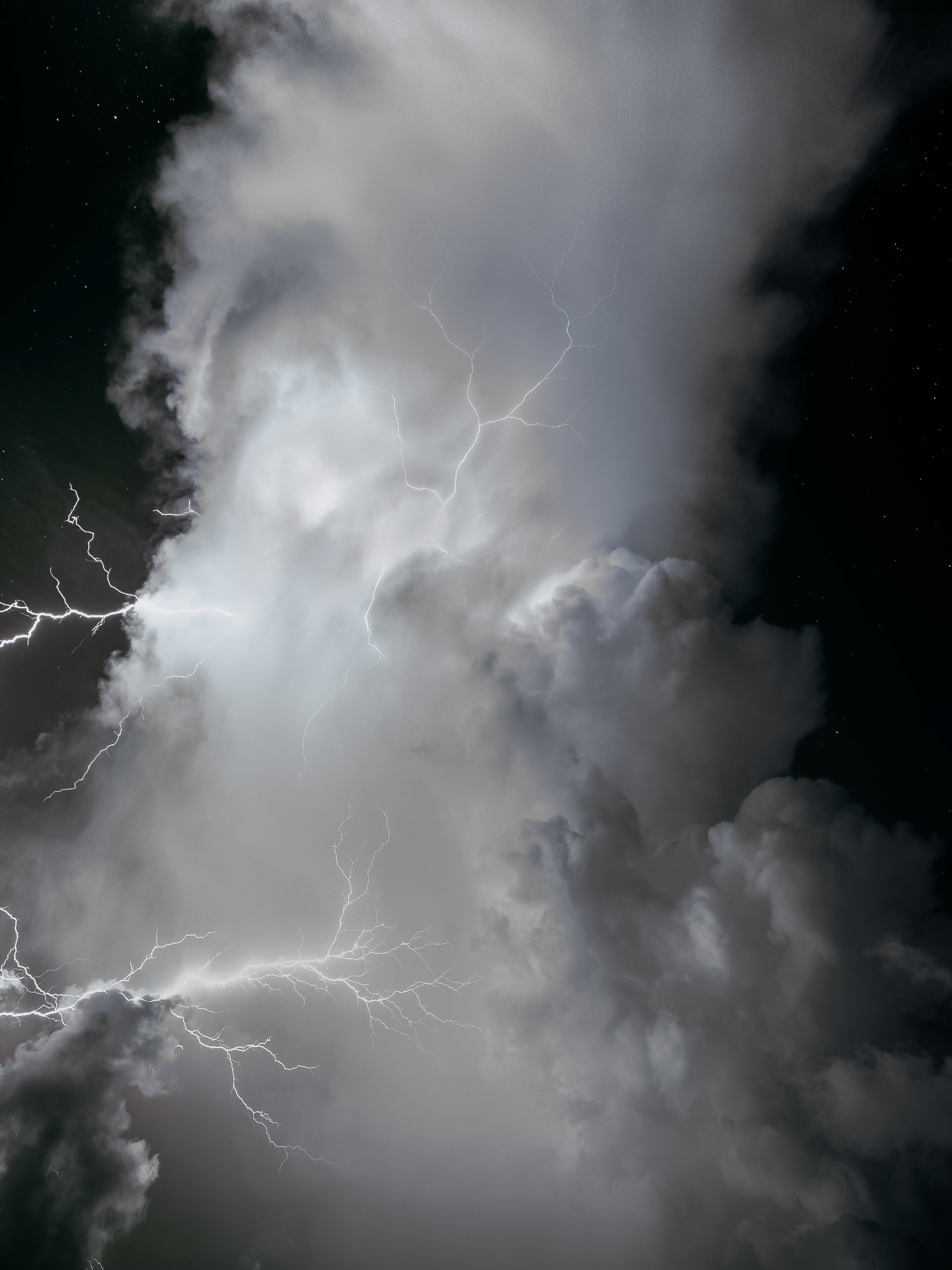 A black-and-white infrared storm cloud crackling with spider lightning against a starry night sky — fine art storm photography by Susan Gunn.